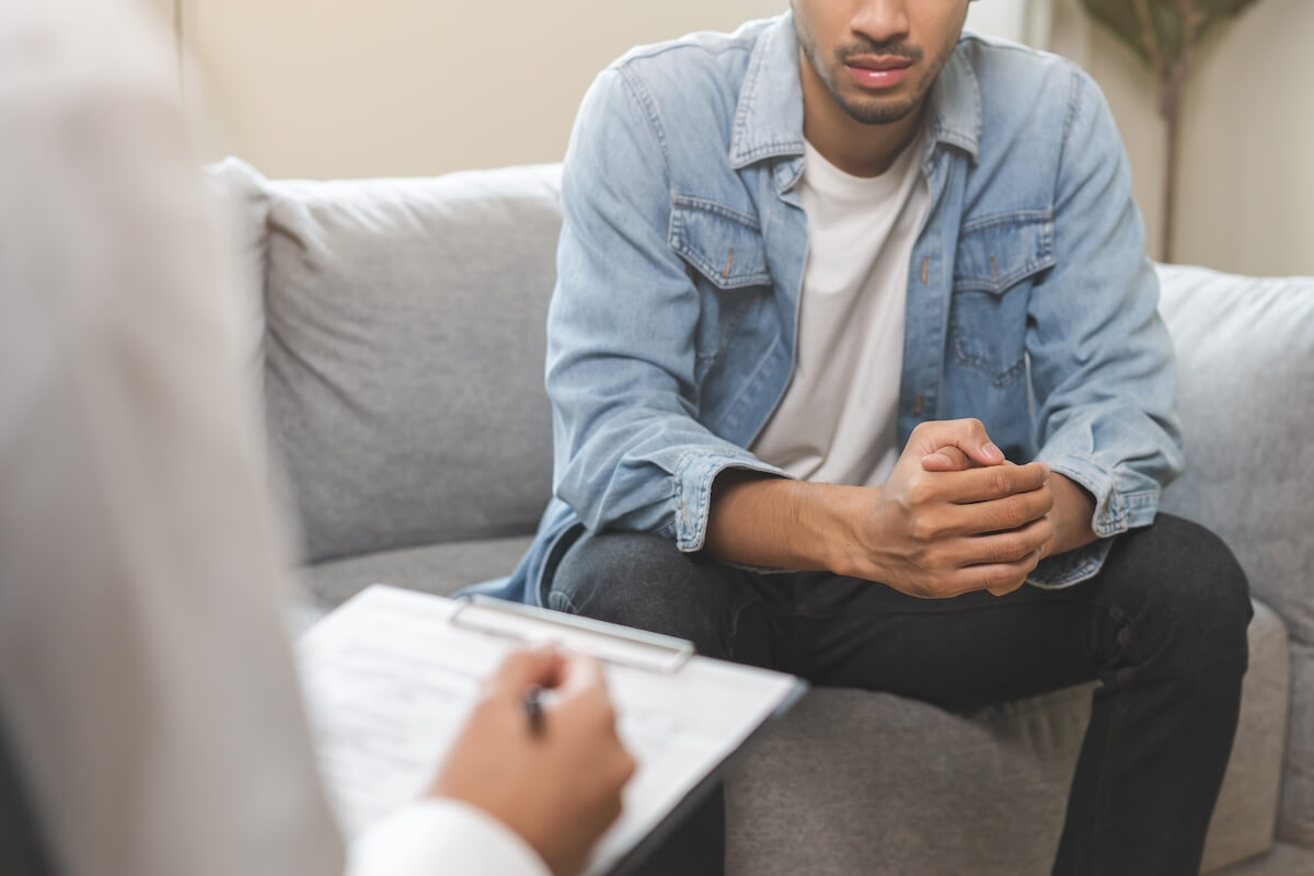 Psychology, depression. Suffer asian young man consultation with psychologist while patient counseling mental therapy, doctor hand taking notes at clinic